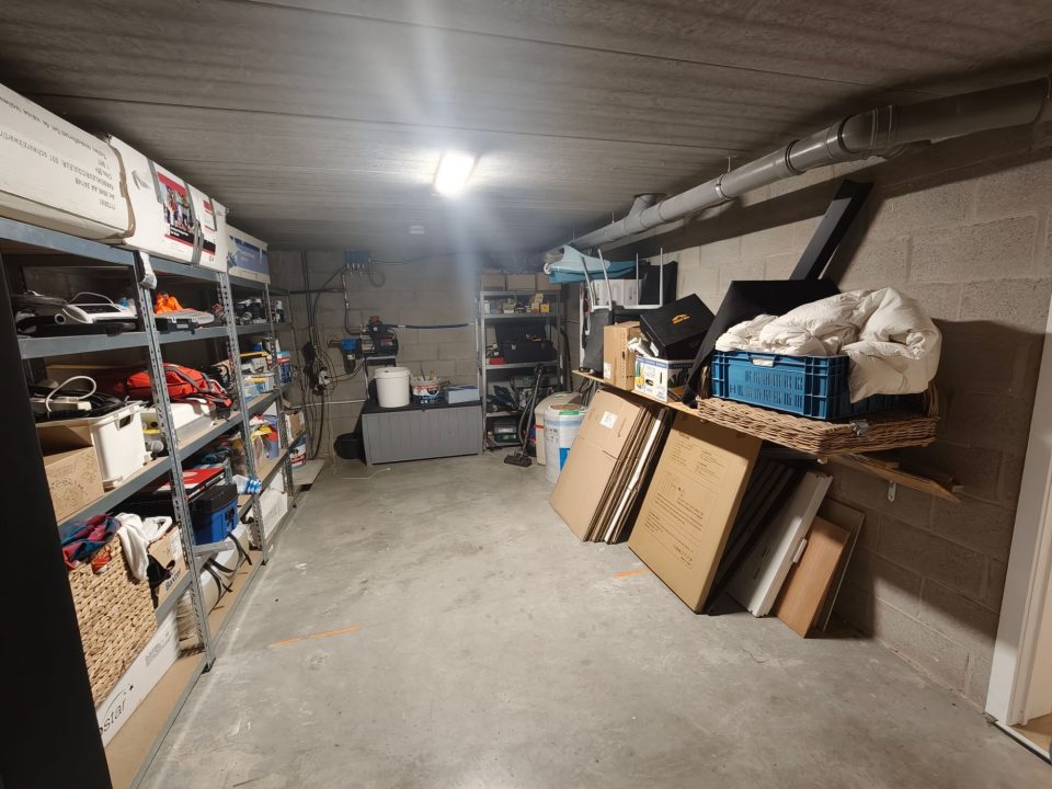 Berging van 18 m² in de kelder met rekken, ontkalker en regenwaterpomp